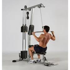 trainer doing lat pulldowns on the Tuffstuff Evolution Lat Pulldown /Low Row (CLM-855WS)