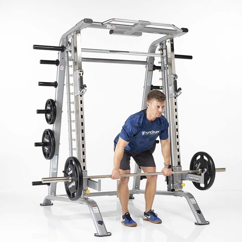 trainer using safety racks in the TuffStuff Evolution Smith Machine / Half Cage (CSM-725WS) to do bent over rows